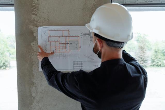 Construction inspector reviewing blueprints on site